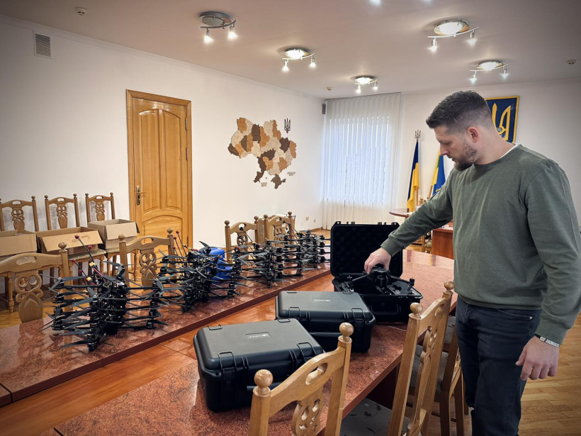 Виконуючий обов'язки Костопільського міського голови Давид Дідух стоїть біля FPV-дронів, які викладені на столі