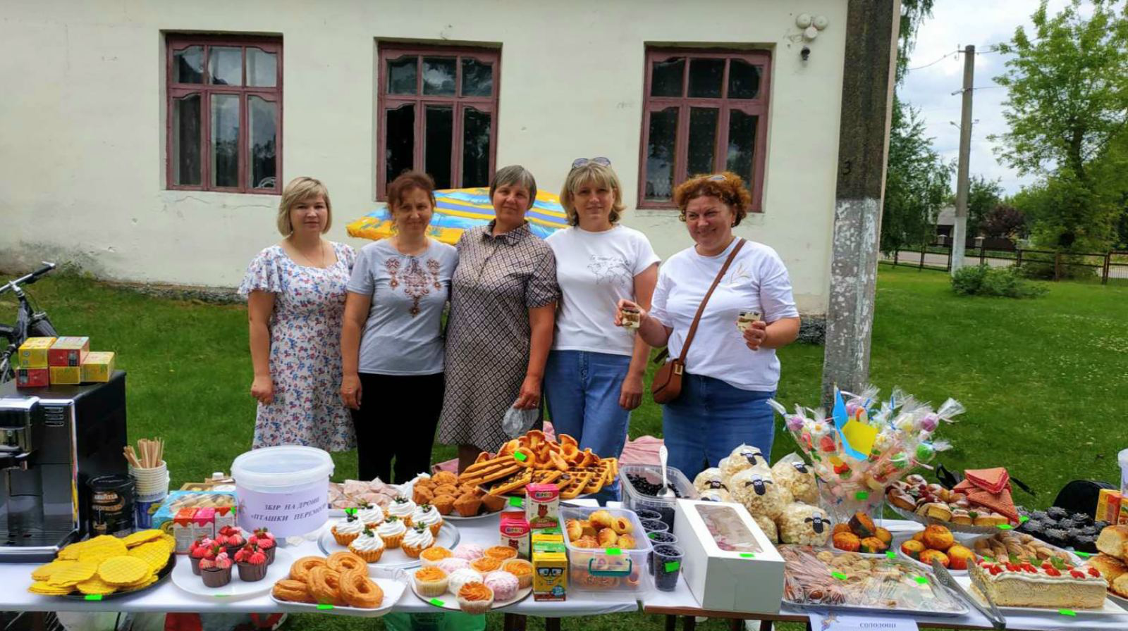 П'ятеро усміхнених учасниць ярмарку пропонують присутнім солодощі