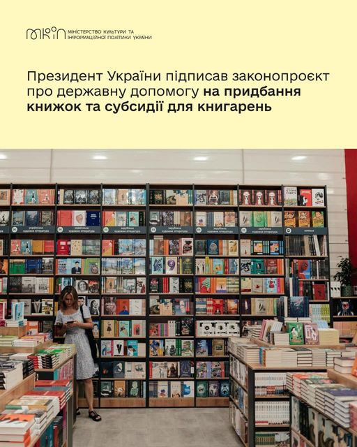 Дівчина у білій сукні стоїть у книгарні, за спиною в неї книжкові полиці