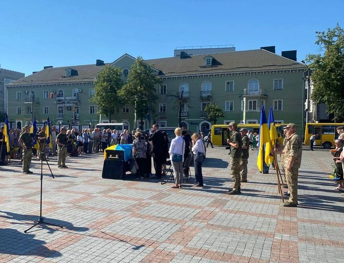 На майдані Незалежності міста Рівне біля труни померлого воїна стоять рідні, почесна  варта з військових, друзі, знайомі, рівняни.