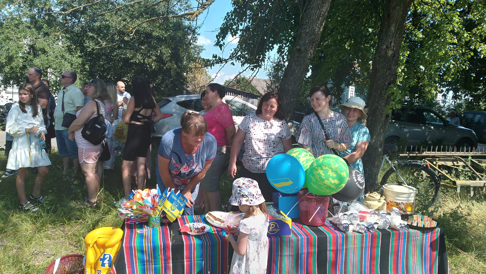 Маленька дівчинка роздивляється сувеніри, які продаються на святі.