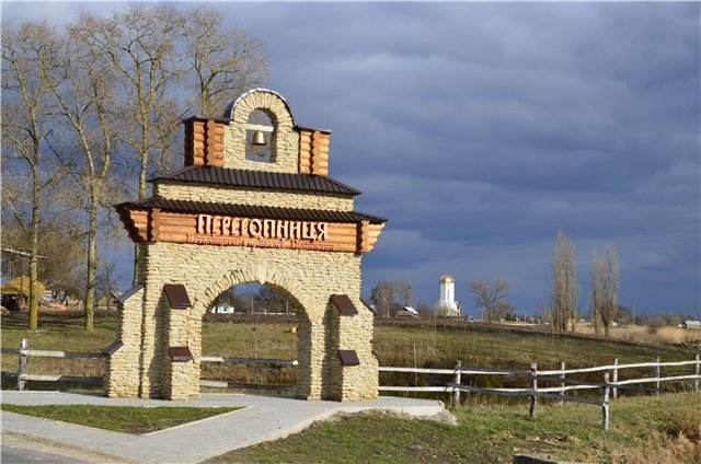 При в'їзді у село стилізована брама з камені, зверху дзвін та написано - Пересопниця, на задньому фоні видніється музей Першокниги