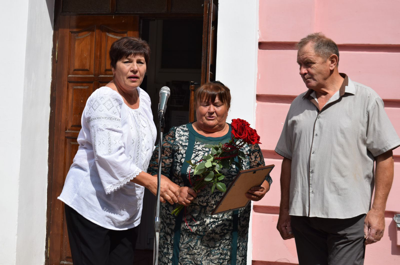 Виконуюча обов'язки голови Здолбунівської міської ради Валентина Капітула вручає батькам воїна Петру та Валентині Дещинським грамоту й квіти