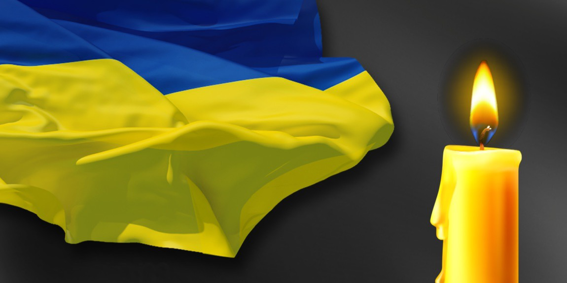 На фото зображені Державний Прапор України та свічка